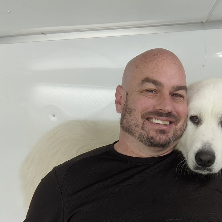 Paul Nickerson with a client's dog in the Hurricane Bath trailer