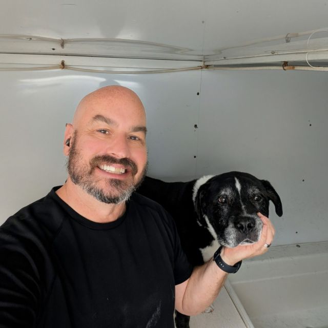 Paul with a black and white dog after his bath