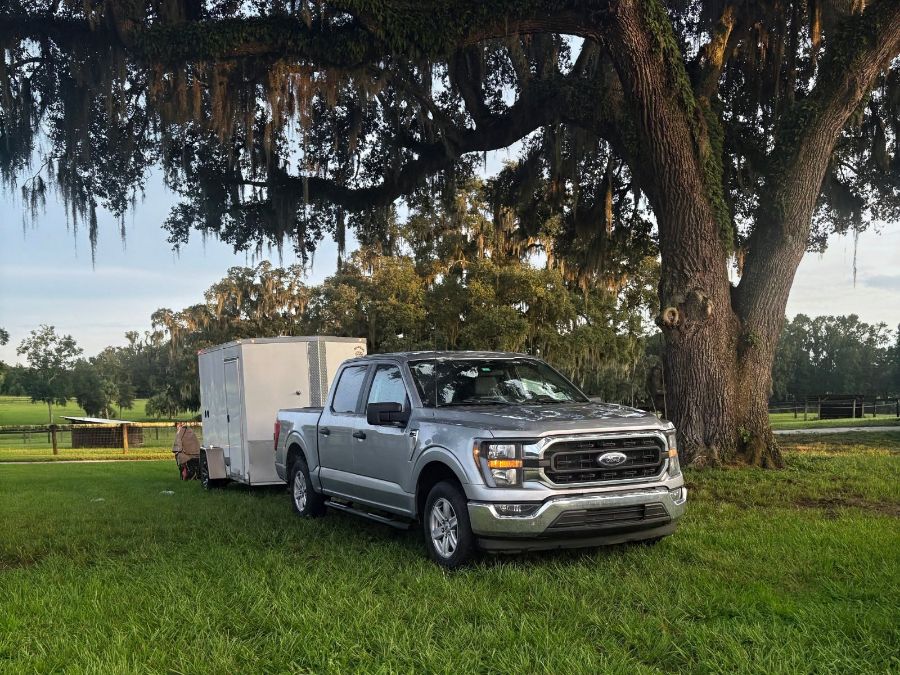 The Dog Gone Clean truck and trailer parked under an oak tree